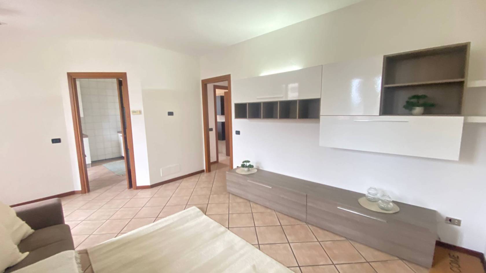 Comodo per la stazione e per l'autostrada, in bel contesto residenziale, ampio tre locali arredato composto da soggiorno con terrazzo e cucina 